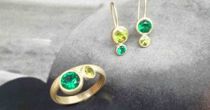 Ohrhänger und Goldring mit grünen Steinen